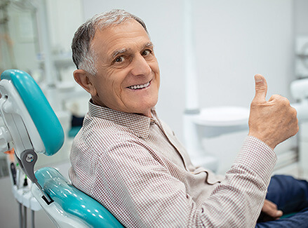 smiling man sitting in a dental chair